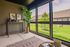 Bright and inviting sunroom with stylish decor, lush greenery, and a serene view of the garden.