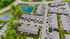 Charming aerial view of a serene apartment complex surrounded by lush greenery and tranquil ponds, offering modern living in a peaceful setting.