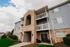 Charming multi-level apartment building with brick and siding facade, featuring private balconies and well-maintained landscaping.