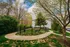 Charming park area with a winding pathway, lush greenery, and a cozy bench, perfect for relaxation and nature walks.