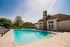 Inviting outdoor pool area with stylish lounge chairs and charming stone-clad clubhouse, perfect for relaxation and gatherings.