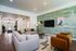 Inviting living room showcasing a luxurious sectional sofa, chic armchairs, and a modern green accent wall with decorative art.