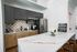 Contemporary kitchen with sleek dark cabinets, stainless steel appliances, and a spacious marble island for dining and entertaining.