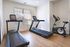 Bright home gym with natural light featuring two treadmills and a stationary bike, perfect for an inspiring workout space.