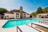 Inviting outdoor pool area with sun loungers and charming clubhouse, perfect for relaxation and gatherings.