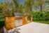 Inviting outdoor kitchen with dual stainless steel grills set against a lush, green backdrop, perfect for entertaining.
