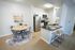 Contemporary kitchen and dining area featuring sleek stainless steel appliances, a cozy round dining table with chic chairs, and a stylish breakfast bar with wooden stools.