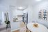 Chic and modern kitchen boasting white cabinetry, stainless steel appliances, and a cozy dining area with stylish decor.