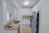 Modern kitchen with sleek stainless steel appliances, chic granite countertops, and elegant white cabinetry, offering a stylish cooking space.