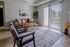 Charming living room with elegant decor featuring a cozy sofa, stylish armchairs, and a sunlit balcony with serene views.