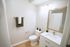 Modern bathroom with elegant vanity, large mirror, and chic decor featuring potted plants.