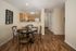 Charming open-concept dining area with elegant wood flooring, modern kitchen, and stylish decor.