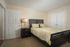 Cozy bedroom with a stylish bed, warm lighting, and contemporary decor, perfect for relaxation.