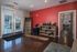 Inviting apartment lobby with stylish red accent wall, modern furniture, and ample natural light through glass doors.