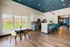 Elegant open-concept kitchen and dining area with sleek blue accents, large windows offering serene outdoor views, and contemporary bar seating.