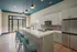 Modern kitchen with sleek cabinetry, spacious island, and elegant pendant lights, opening to a bright patio view.