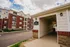Charming apartment complex with brick facade and convenient mail pavilion, set against a bright sky.
