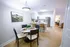 Modern dining and kitchen area with elegant lighting, chic furnishings, and a sleek stainless steel refrigerator.