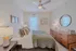 Charming bedroom with cozy bedding, stylish wooden dresser, elegant lamps, and a serene atmosphere.