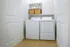 Bright laundry room featuring modern washer and dryer set with stylish shelving for organized storage.