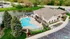Inviting aerial view of luxury apartment community featuring a stunning outdoor pool, lush green landscaping, and modern clubhouse.