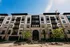 Modern Essex apartment building exterior showcasing elegant architecture with balconies and lush greenery, bathed in sunlight.