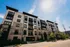 Elegant apartment complex Essex with modern architecture, featuring large windows and balconies under a clear blue sky.