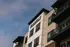 Elegant apartment building exterior with modern balconies and stylish facade, showcasing 'FAIRFAX' signage.