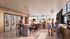 Modern communal lounge with comfortable seating, large screen TV, and chic kitchen area, ideal for socializing and relaxation.