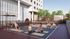 Inviting outdoor yoga space with people enjoying a relaxing session on mats, surrounded by lush greenery and modern architecture.