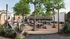 Vibrant apartment community outdoor space featuring lush greenery, cozy seating, and a sleek modern trailer under string lights, perfect for social gatherings.