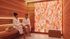 Luxurious spa room with two women relaxing in robes, warm wooden walls, and a striking Himalayan salt wall panel.