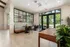 Elegant apartment lobby with modern seating area, large windows, and inviting greenery.
