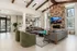 Elegant living room with high ceilings, featuring a cozy fireplace, stylish gray sofas, and contemporary decor, seamlessly connected to a modern kitchen.