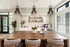 Chic communal area with a stylish wood table, modern pendant lighting, and elegant decor, perfect for relaxation and gatherings.