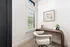 Charming home office nook with a modern wooden desk, plush chair, and large window letting in natural light.