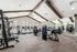 Modern fitness center with high ceilings, equipped with treadmills, strength machines, and a mirrored wall for a dynamic workout experience.