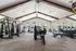 Spacious and modern gym with state-of-the-art exercise equipment, abundant natural light, and high ceilings, perfect for fitness enthusiasts.