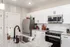 Modern kitchen featuring sleek granite countertops, stainless steel appliances, and stylish white cabinetry, perfect for culinary enthusiasts.