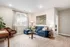 Inviting living room with a plush blue sofa, elegant decor, and abundant natural light creating a cozy atmosphere.