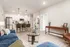 Contemporary open-concept living area with a cozy seating arrangement, stylish kitchen with bar stools, and elegant decor.