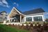 Charming leasing office with lush landscaping under a bright blue sky.