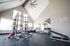 Bright and spacious fitness center equipped with modern gym equipment and high ceilings, perfect for an invigorating workout experience.