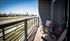 Charming balcony with cozy seating and vibrant flowers, offering scenic views of a suburban neighborhood and lush greenery.