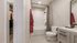 Elegant bathroom with modern vanity, chic gray tiles, and spacious shower-tub combo.