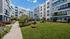 Charming apartment complex with vibrant exterior colors, lush landscaped courtyard, and cozy outdoor seating.