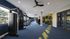 Spacious and modern apartment gym with top-of-the-line fitness equipment, vibrant carpet design, and ample natural light.