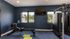 Modern fitness room with sleek rowing machine, bright windows, and a mounted TV, perfect for energizing workouts.