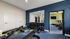 Modern fitness room with sleek benches, free weights, and state-of-the-art treadmills, highlighted by vibrant blue and green walls.