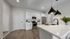Modern kitchen with sleek white cabinetry, stainless steel appliances, and elegant pendant lighting over a spacious island.